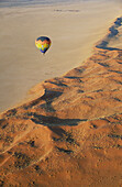 At a perfect morning the hot-air balloon glides smoothly along the edge of the Namib Desert. Namib-Naukluft Park, Namibia.
