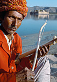 Musician playing the choutara instrument. Jal Mahal or water palace. Jaipur. Rajasthan. India