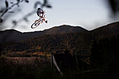 Young man jumping with a mountainbike, Oberammergau, Bavaria, Germany