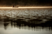 Man fishing on Lake Alpsee in the morning, Schwangau, Bavaria, Germany