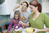 Young family preparing a salad in a domestic kitchen, Munich, Germany