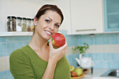 Young woman eating an apple, Munich, Germany