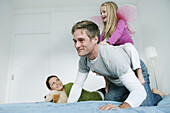 Young family playing on bed, Munich, Germany