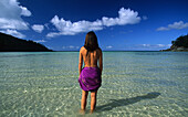 Woman standing in water on the beach, Dinghy Bay auf Brampton Island, Whitsunday Islands, Great Barrier Reef, Australia