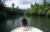 Kleines Mädchen sitzt am Bug eines Bootes, Bootsfahrt auf dem Apoomau River, Raiatea, Französisch Polynesien, Südsee