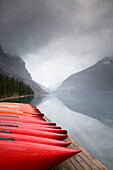 Red canoes and lake in early winter. Lake Louise, Banff National Park. Alberta, Canada