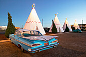 Wigwam motel concrete teepees and 1959 Chevrolet on Route 66 at evening. Holbrook. Arizona, USA