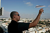 Mann wirft Papierflieger, Sevilla, Andalusien, Spanien, Europa