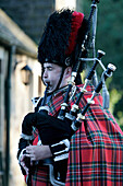 Scottish piper, Man playing the bagpipes in traditional dress, Southern Highlands, Scotland, Great Britain, Europe
