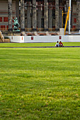 Teo people sitting on the grass outside the Old Museum, renovation work, Berlin, Germany