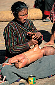 Woman massaging a baby. Bhaktapur. Nepal