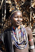 Young Erbore tribe girl in front of her straw and wooden hut. Shepherds tribe from south Ethiopia.