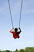 Boy in red shirt on swing