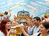 Junge Leute feiern auf dem Oktoberfest, München, Bayern, Deutschland