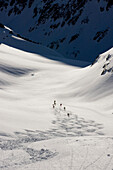 Gruppe Skifahrer beim Freeride ins Val Strem, Sedrun, Graubünden, Schweiz