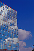 All-window side of office building reflecting blue sky and clouds, clouds peeking from behind building, deep blue sky, Keystone Crossing. Indianapolis. USA