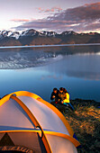 Couple cooking meal by tent. Chugach State Park. Southcentral Alaska