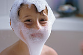 Young boy in bath with soapy face