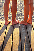 Couple s feet together at beach boardwalk