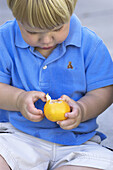 toddler peeling tangerine
