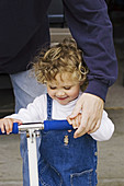 Dad with daughter on skate toy