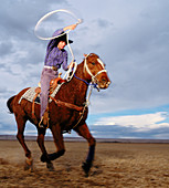 Teenage girl rodeo champion roping on horseback. Colorado. USA