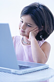 Childhood, Children, Color, Colour, Computer, Computers, Contemporary, Dark-haired, Education, Facial expression, Facial expressions, Female, Girl, Girls, Grin, Grinning, Head, Heads, Human, Indoor