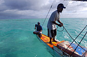 Marshalhese men steering a traditional outrigger canoe, Ailuk atoll, Marshall Islands, Pacific