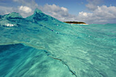 Split image of wave showing sandy bottom and Island, Rongelap, Marshall Islands, Micronesia