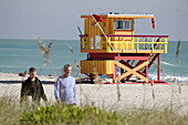 Lifeguard station, father, son, beachcombers, sand. Atlantic shore. Miami Beach. Florida. USA.