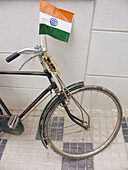 Older bicycle with an Indian flag on a street in Bangalore, India