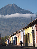 A view of the nearby vocano and the colorfully painted Colonial style houses in Antigua, Guatemala.