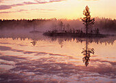 Misty summernight at lake and sunrise. Byske, Västerbotten, Sweden