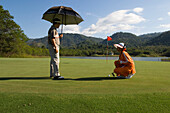 Man playing golf, Caddy, Krimaya Golf Course, Khao Yai National Park, Thailand