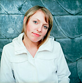 Young woman in front of a slate wall looking at camera, portrait, Düsseldorf, North Rhine-Westphalia, Germany