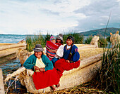 Uru indian women and totora reeds boat. Titicaca Lake. Peru