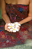 Frau hält Blumen in einem Spa. Insel Koh Samui. Thailand