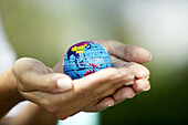 Woman hands holding small world globe