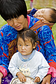 Bhutan. Thimpu. Thimpu Dzong Monastery. Buddhist Festival (Tsechu). Bhutanese woman with children