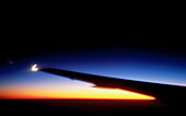 Airplane wing over sunrise