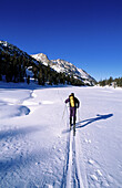 John Muir Wilderness. Skier crossing a snowy meadow in the Little Lakes Valley. Inyo National Forest. California. USA