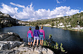Kids enjoying the view along the shore of Boothe Lake, in the Cathedral Range, Sierra Nevada Mountains. Yosemite NP. California. USA