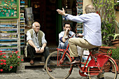 Conversation with red bicycle, Lucca. Tuscany, Italy