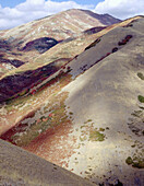 Clouds cast shadows on rolling hills and fall colors near Salt Lake City. Utah. USA