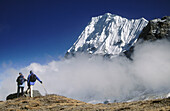Trekkers. Wedge Peak above cloud. Lhonak. Kangchenjunga. East Nepal