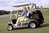 Mature couple riding a golf cart