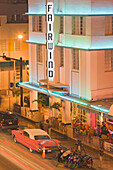 Vintage car in front of the illuminated Fairwind Hotel on Collins Avenue, Miami Beach, Miami, Florida, USA