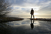 Man standing at lakeshore of Lake Starnberg, Bavaria, Germany
