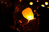 People lighting skylaterns on new year, Munsing, Bavaria, Germany