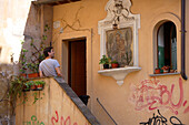 Mann steht vor einem Hauseingang im Stadtteil Trastevere, Rom, Italien, Europa